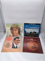 Front covers of John Denver, Camelot soundtrack, Carl Smith Greatest Hits, unidentified brown cover LP