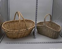 Two oval wicker baskets side-by-side with rulers for scale