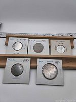 Group shot of five coins in individual holders