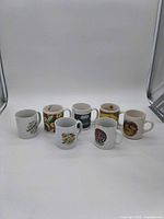 Front view of all seven mugs showing designs