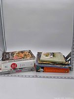 Both stacks of nine cookbooks with ruler for scale
