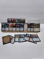 Front view showing majority of the 25 MTG cards on wooden stand plus extras in front