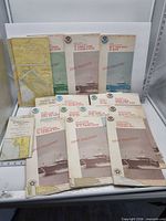Group view of multiple folded NOAA charts showing covers and quantity
