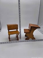 Both miniature wooden chairs with measuring tape for scale
