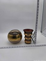 Size comparison of both vases beside ruler, showing heights