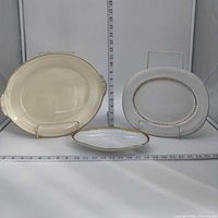 Group shot of three oval platters with rulers for scale