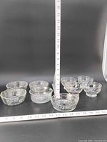 All nine clear glass bowls arranged with rulers for scale