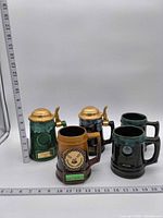 All five steins and mugs with rulers for scale