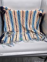 Full view of striped afghan draped over chair