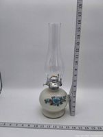 Full view of oil lamp beside ruler showing overall height