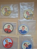 All six 1960s hockey player coins in individual plastic sleeves on tabletop