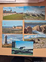 Seven colour postcards laid out on desk