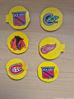 Front view of six yellow cardboard inserts showing different NHL logos