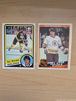 Front view of two 1983-84 Ray Bourque hockey cards, regular issue and All-Star subset