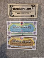 Becker’s 5 ¢ cash coupon with Pioneer Bonus Bucks 5 and 10 denominations on grey surface