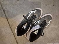 Top view of both black and white Mizuno football cleats showing uppers and laces