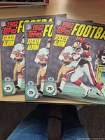 Front covers of three 1982 Topps NFL sticker albums