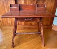 Front view of cherry wood desk showing top organizer and legs