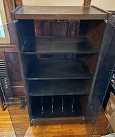 Front view of cabinet with doors open showing three shelves and record dividers