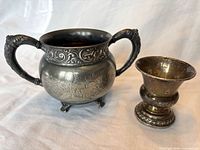 Front view of both silver vessels showing design, handles, feet, comparative sizes
