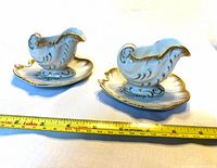 both gravy boats on saucers with tape measure showing length