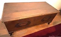 Top and front view of wooden Lane cedar chest showing handles and feet