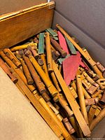 Box containing mixed lengths of brown notched logs, green roof planks, red gable boards