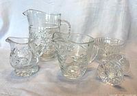 Front view of pitcher, two creamers, sugar bowl, utensil rest