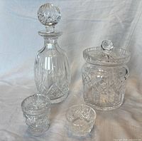 Overall view showing decanter with stopper, jar with lid, salt bowl, sugar bowl, crystal spoon (spoon partially visible)