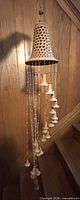 Full view of entire terracotta wind chime hanging on wall