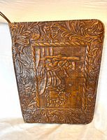 Front of embossed leather portfolio with pastoral carving