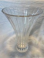Full view of clear glass fluted vase showing trumpet flare and stepped base