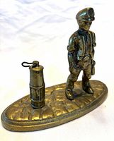 Front view of brass miner figurine and lamp on oval base