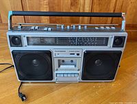 Front view showing model, speakers, cassette deck, tuner and controls