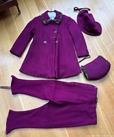 Full snowsuit set laid out: coat, pants, bonnet, muff