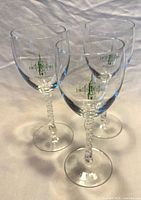 Three clear glass goblets with green 1991 USF logo and twisted stems