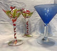 Two holiday motif glasses and two blue spiral glasses side by side