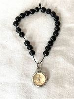 Full view of beaded pendant watch showing corded bead strand and watch