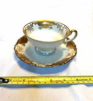 Teacup on saucer with measuring tape showing scale