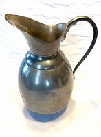 Side view of pewter pitcher showing spout, handle, baluster form