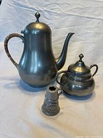 Teapot, sugar bowl and taper tipper displayed together