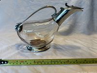 Side profile of entire duck decanter with tape measure for scale