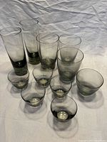 All eleven smoky grey tumblers grouped, showing size variation and gradient color
