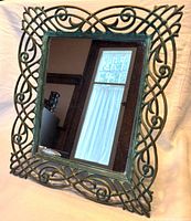 Front view of ornate verdigris metal framed mirror