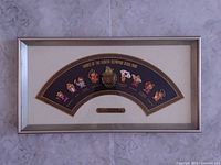 Full view of framed pin set showing fan-shaped board, eight pins, central emblem, nameplate, and frame.