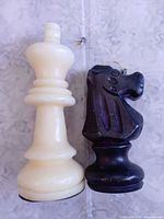 White king and black knight wax candles side by side