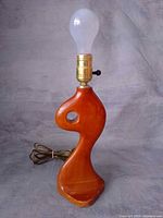Full view of sculptural wood lamp with bulb installed