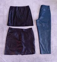 Two faux-leather skirts and one pair blue pants