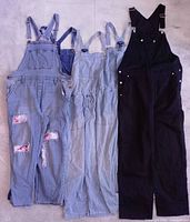 Four pairs of women’s overalls laid flat showing full length and color variety