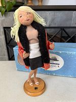 Full view of Annalee 13" cloth doll on wooden base with box in background